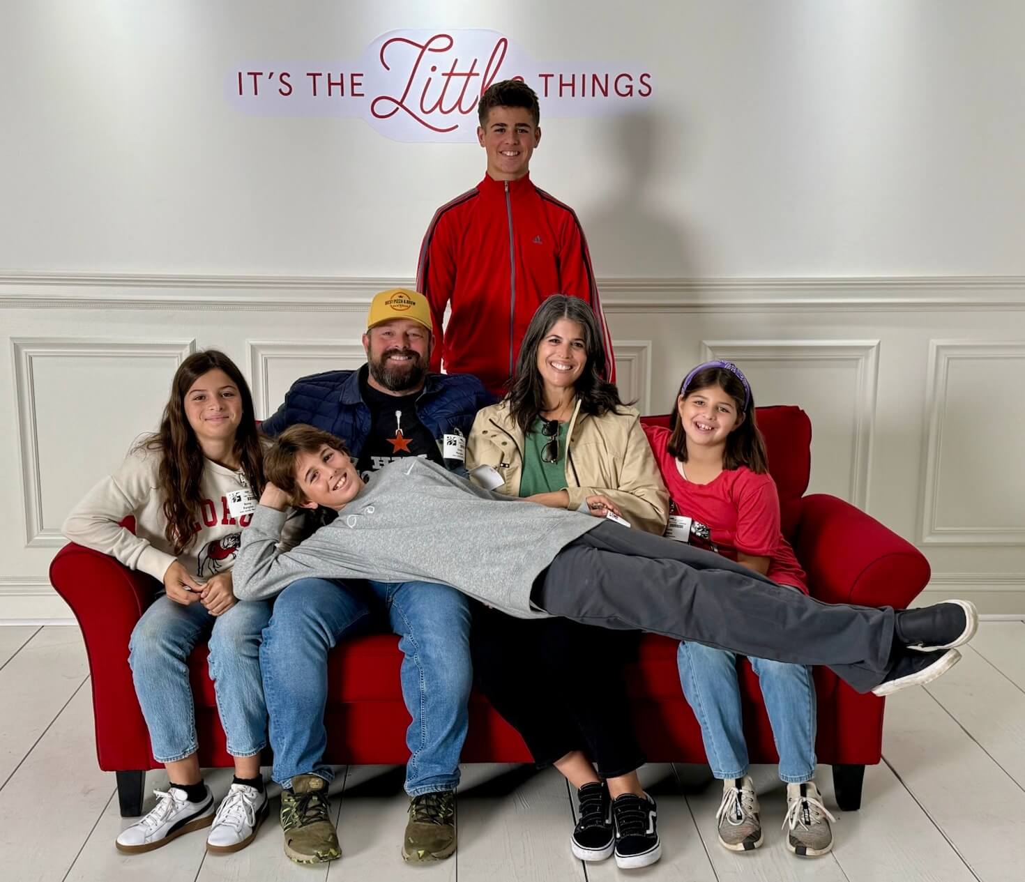 Chris Ranglas with his wife and four children seated together on a red couch
